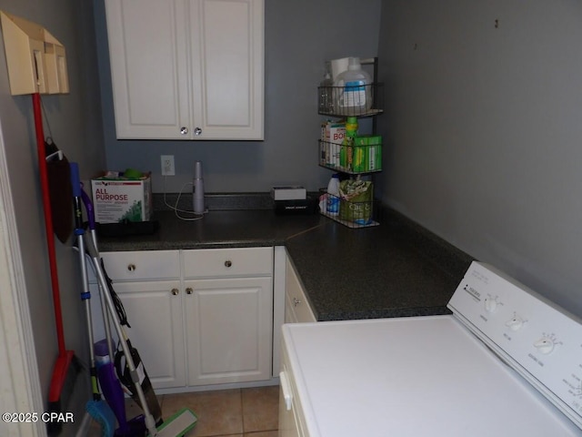 washroom with cabinets, light tile patterned flooring, and washer / dryer