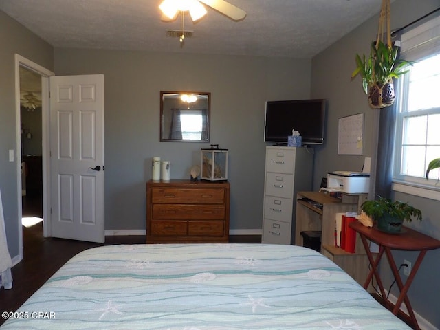 bedroom featuring a textured ceiling, dark hardwood / wood-style floors, and ceiling fan