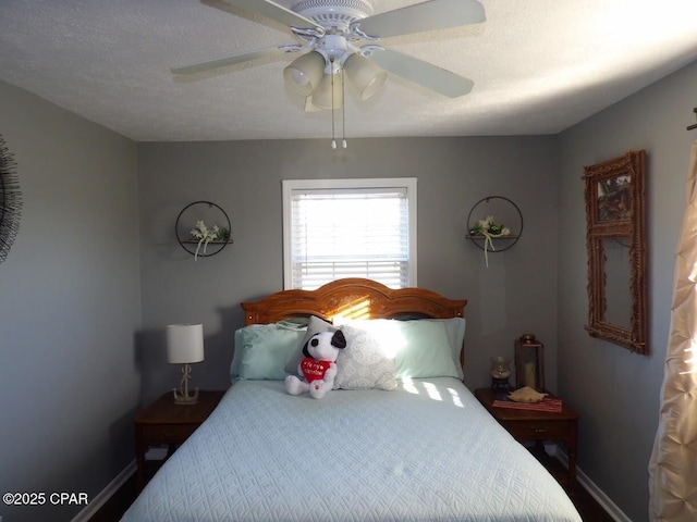 bedroom with ceiling fan and a textured ceiling