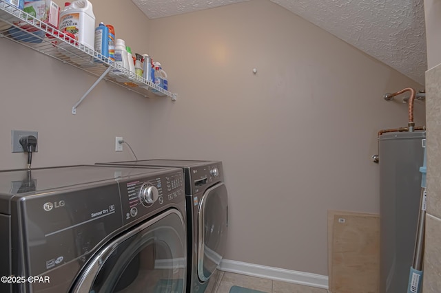 clothes washing area with washer and clothes dryer, laundry area, a textured ceiling, and water heater