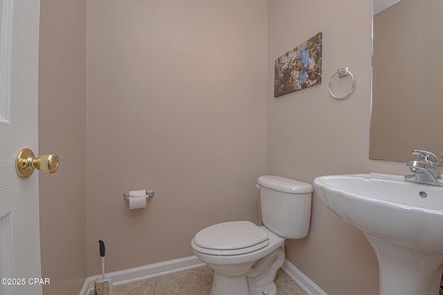 bathroom featuring tile patterned floors, toilet, and baseboards