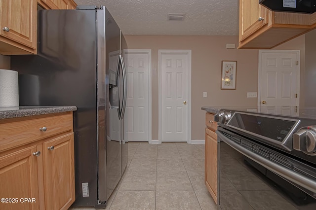 kitchen with visible vents, range with electric cooktop, stainless steel refrigerator with ice dispenser, light tile patterned flooring, and a textured ceiling