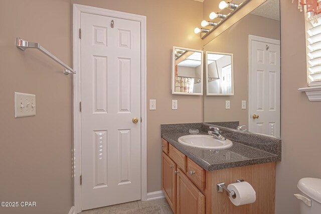 bathroom featuring vanity, tile patterned flooring, and toilet