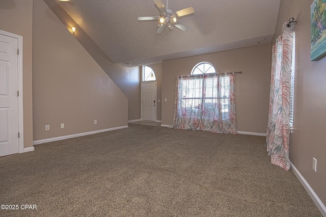 interior space with lofted ceiling, ceiling fan, a textured ceiling, and carpet flooring