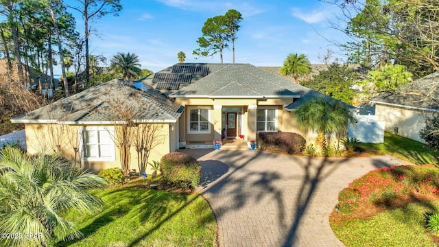 view of front facade with solar panels and a front yard