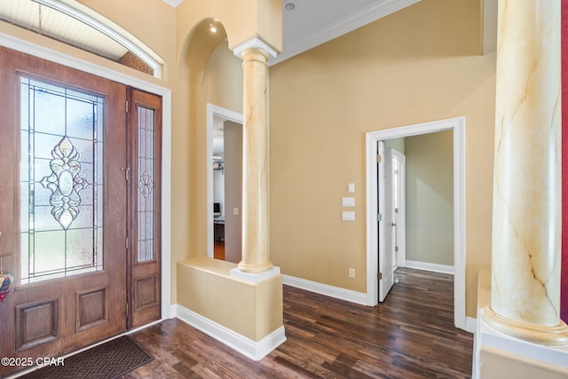 foyer entrance featuring ornamental molding, dark wood-type flooring, and decorative columns