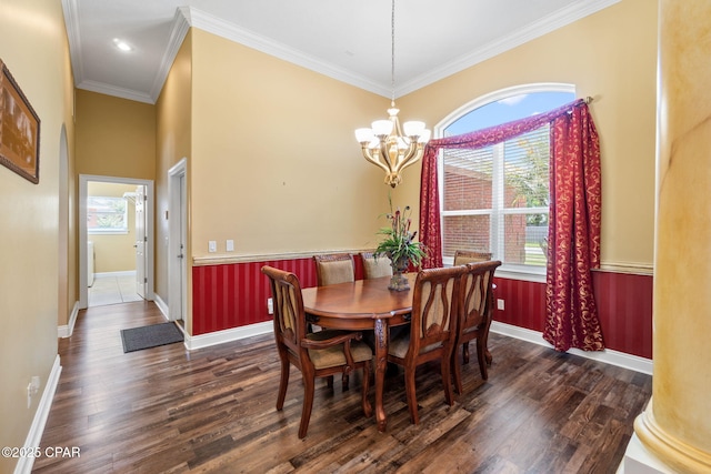 dining room with an inviting chandelier, ornamental molding, dark wood-type flooring, and ornate columns