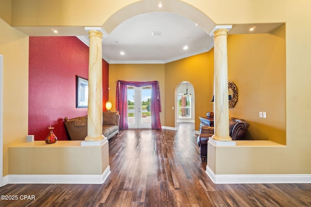 foyer entrance with dark hardwood / wood-style floors, decorative columns, ornamental molding, and french doors