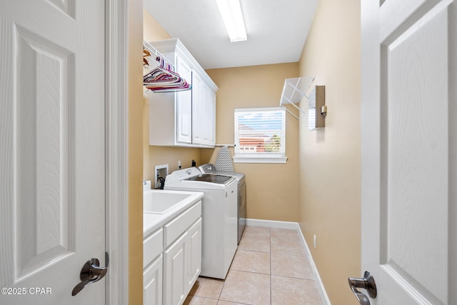 laundry area with cabinets, light tile patterned floors, and separate washer and dryer