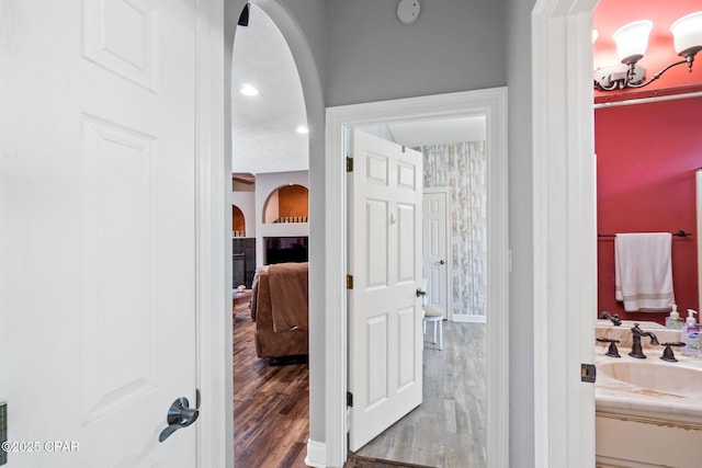 bathroom featuring a tile fireplace, hardwood / wood-style flooring, and a notable chandelier