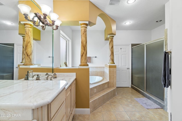 bathroom with vanity, tile patterned flooring, separate shower and tub, ornate columns, and a textured ceiling