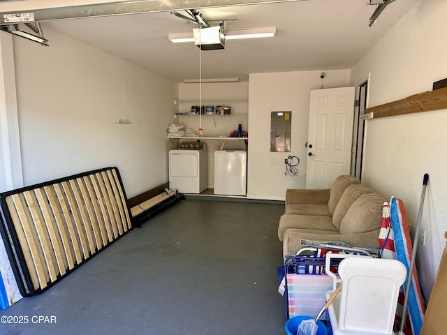 garage featuring washing machine and clothes dryer, electric panel, and a garage door opener