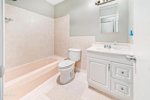 bathroom with tile patterned flooring, toilet, vanity, bathing tub / shower combination, and tile walls