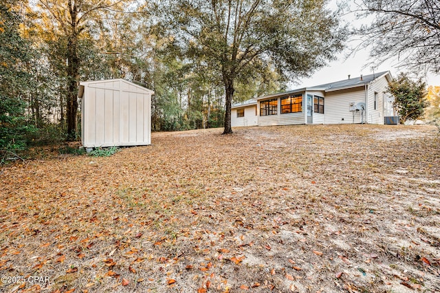 view of yard with an outbuilding, central AC, and a shed