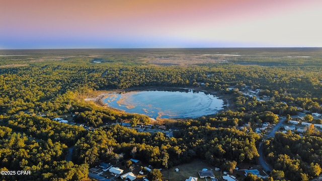 aerial view at dusk featuring a water view