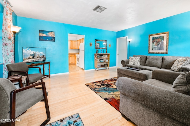 living room featuring baseboards, visible vents, and light wood-type flooring