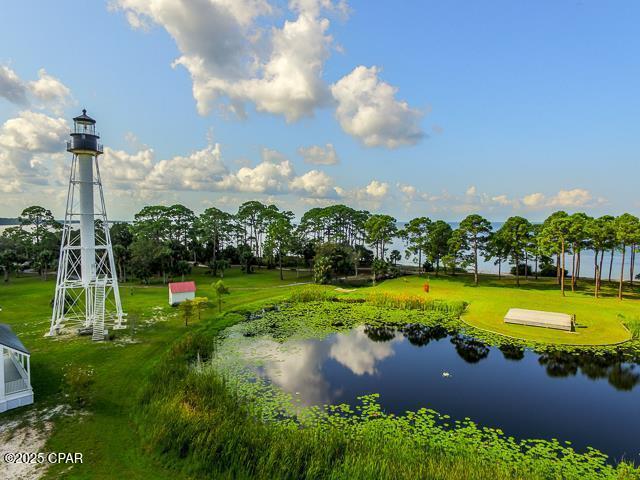 surrounding community featuring a water view and a lawn