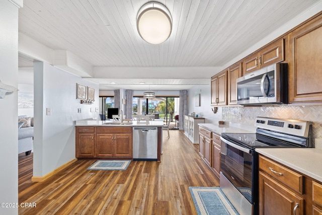 kitchen featuring tasteful backsplash, wood ceiling, hanging light fixtures, dark wood-type flooring, and stainless steel appliances