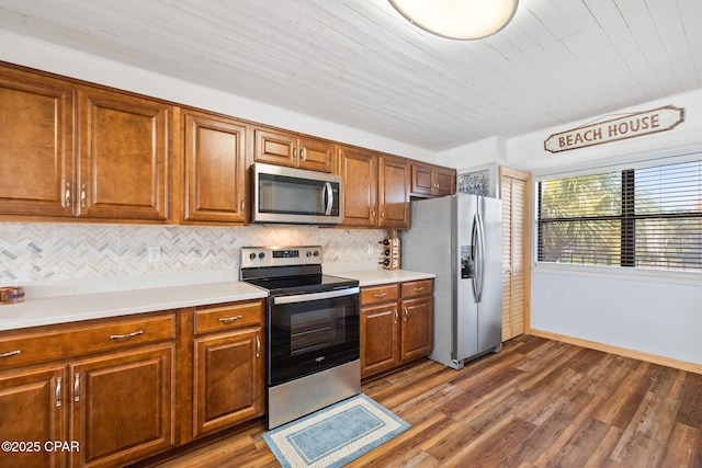 kitchen with dark wood-type flooring, backsplash, appliances with stainless steel finishes, and wood ceiling