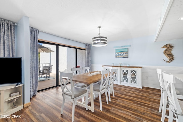 dining area featuring dark wood-type flooring and a notable chandelier