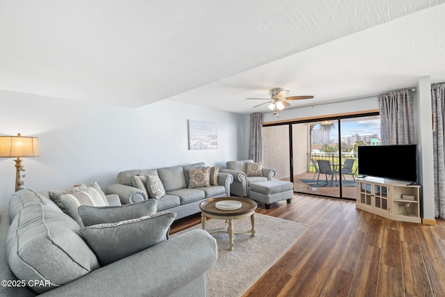 living room with ceiling fan and dark hardwood / wood-style floors