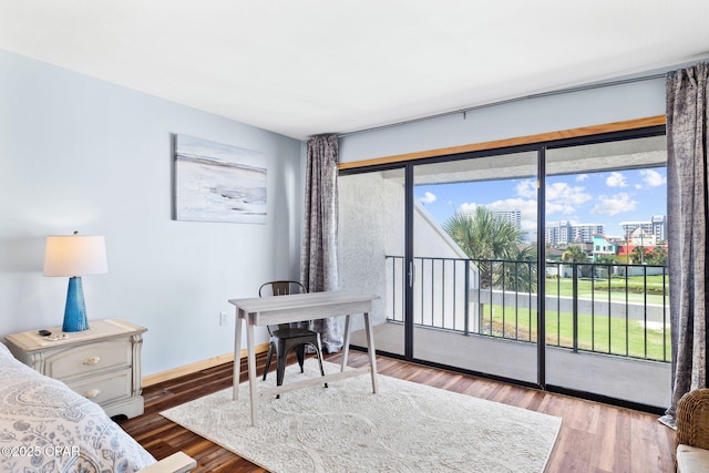 bedroom featuring wood-type flooring, access to outside, and multiple windows