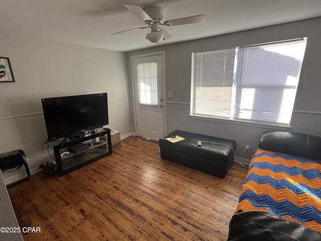 living room with dark hardwood / wood-style flooring and ceiling fan