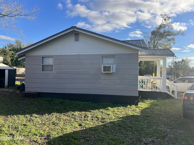 view of side of property with covered porch and a yard