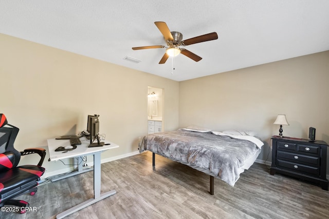 bedroom with hardwood / wood-style floors, connected bathroom, a textured ceiling, and ceiling fan