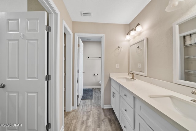 bathroom featuring hardwood / wood-style floors, vanity, a textured ceiling, and toilet