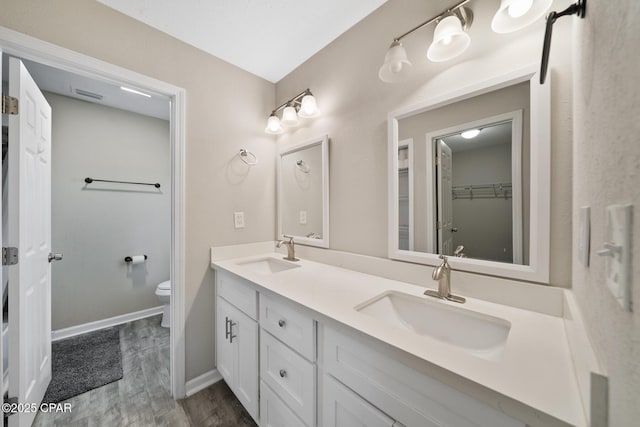 bathroom with hardwood / wood-style flooring, vanity, and toilet