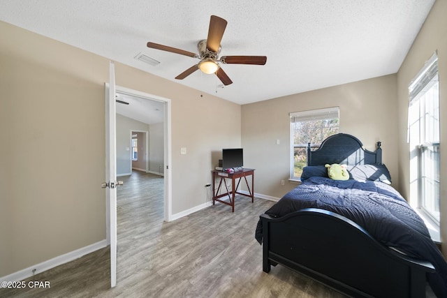 bedroom with a textured ceiling, ceiling fan, hardwood / wood-style floors, and lofted ceiling