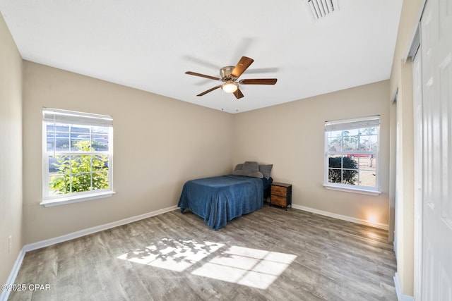 unfurnished bedroom featuring multiple windows, ceiling fan, and light hardwood / wood-style floors