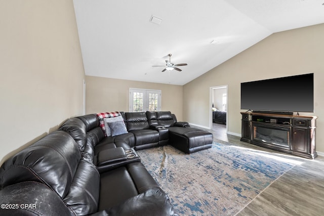 living room with hardwood / wood-style flooring, ceiling fan, and vaulted ceiling