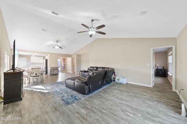 living room with hardwood / wood-style flooring, ceiling fan, a textured ceiling, and vaulted ceiling