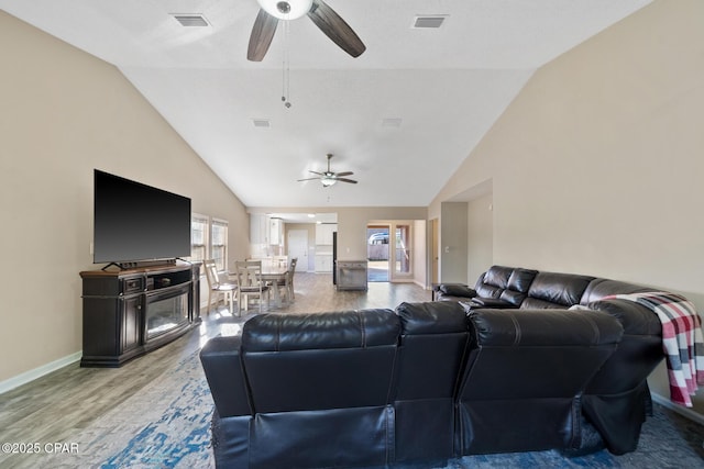 living room with ceiling fan, hardwood / wood-style floors, and vaulted ceiling