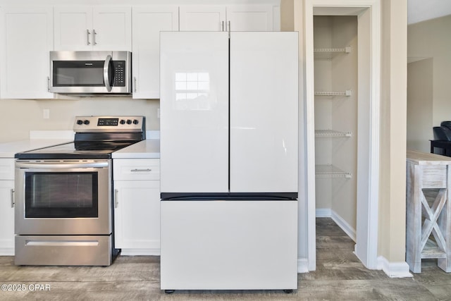 kitchen with white cabinetry, light hardwood / wood-style flooring, and stainless steel appliances