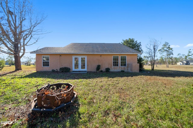 back of property featuring a lawn and french doors