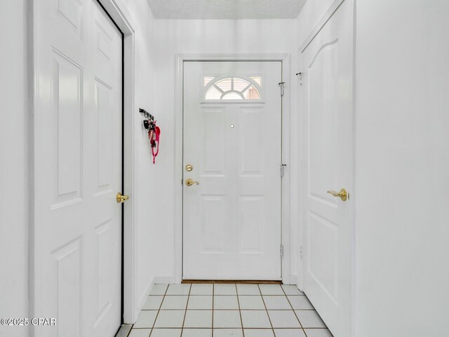 entryway featuring a textured ceiling and light tile patterned floors