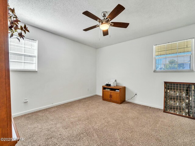 empty room with carpet floors, a textured ceiling, and ceiling fan