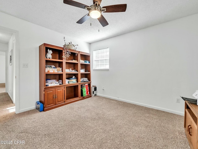 interior space featuring carpet floors, a textured ceiling, and ceiling fan