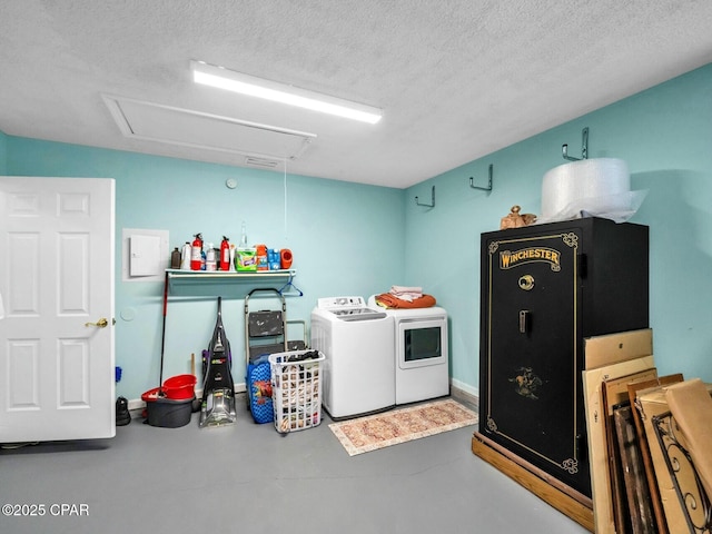 laundry area with independent washer and dryer and a textured ceiling