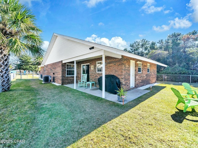 back of property with a patio, a lawn, and central air condition unit