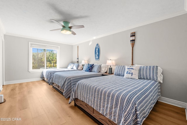 bedroom with ceiling fan, hardwood / wood-style floors, a textured ceiling, and ornamental molding