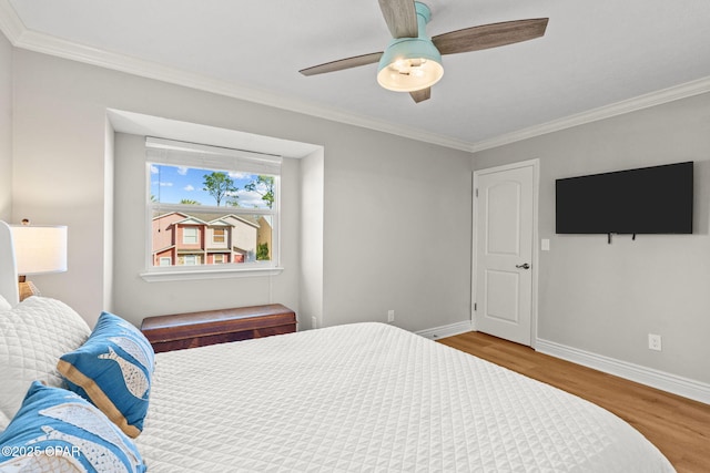 bedroom featuring hardwood / wood-style flooring, ceiling fan, and crown molding