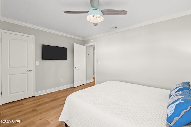 bedroom with ceiling fan, hardwood / wood-style floors, and ornamental molding