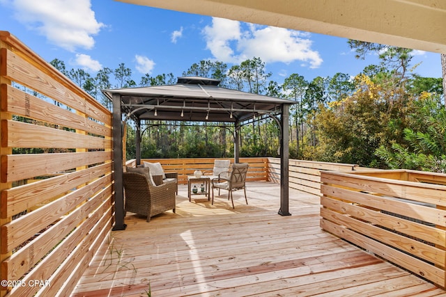 wooden terrace featuring a gazebo and an outdoor living space