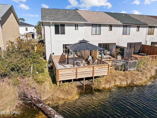 back of property featuring a deck with water view