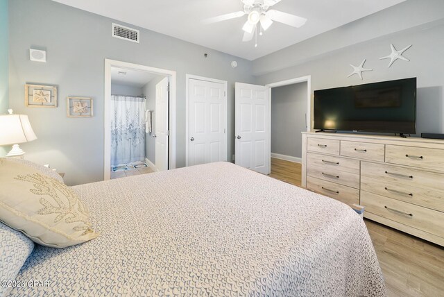 bedroom featuring ensuite bath, light hardwood / wood-style flooring, and ceiling fan