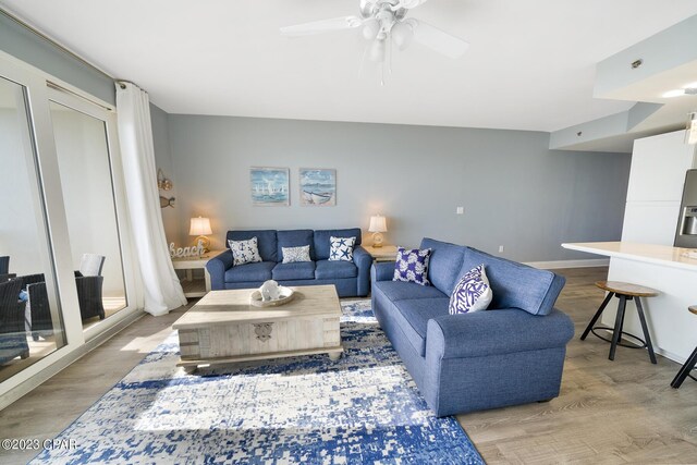 living room featuring ceiling fan and light hardwood / wood-style flooring